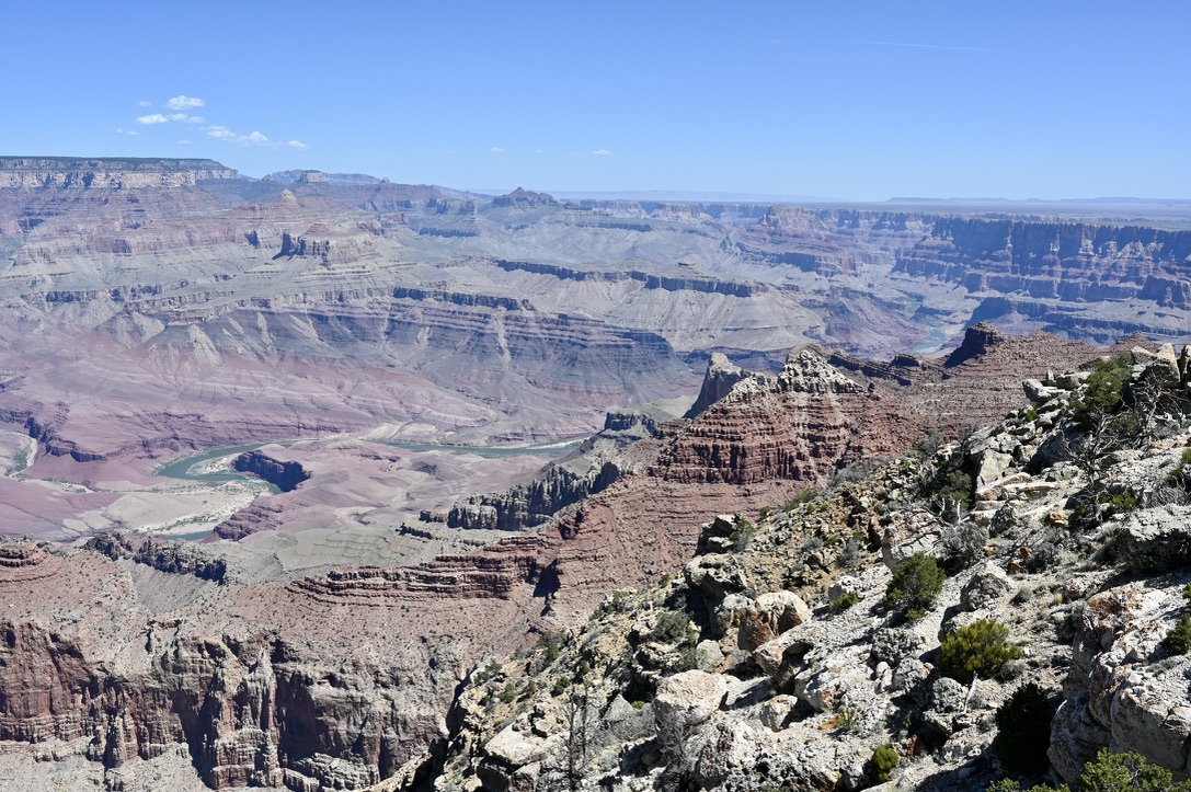 Grand canyon view with red, orange and gray canyon walls and colorado river snaking around.