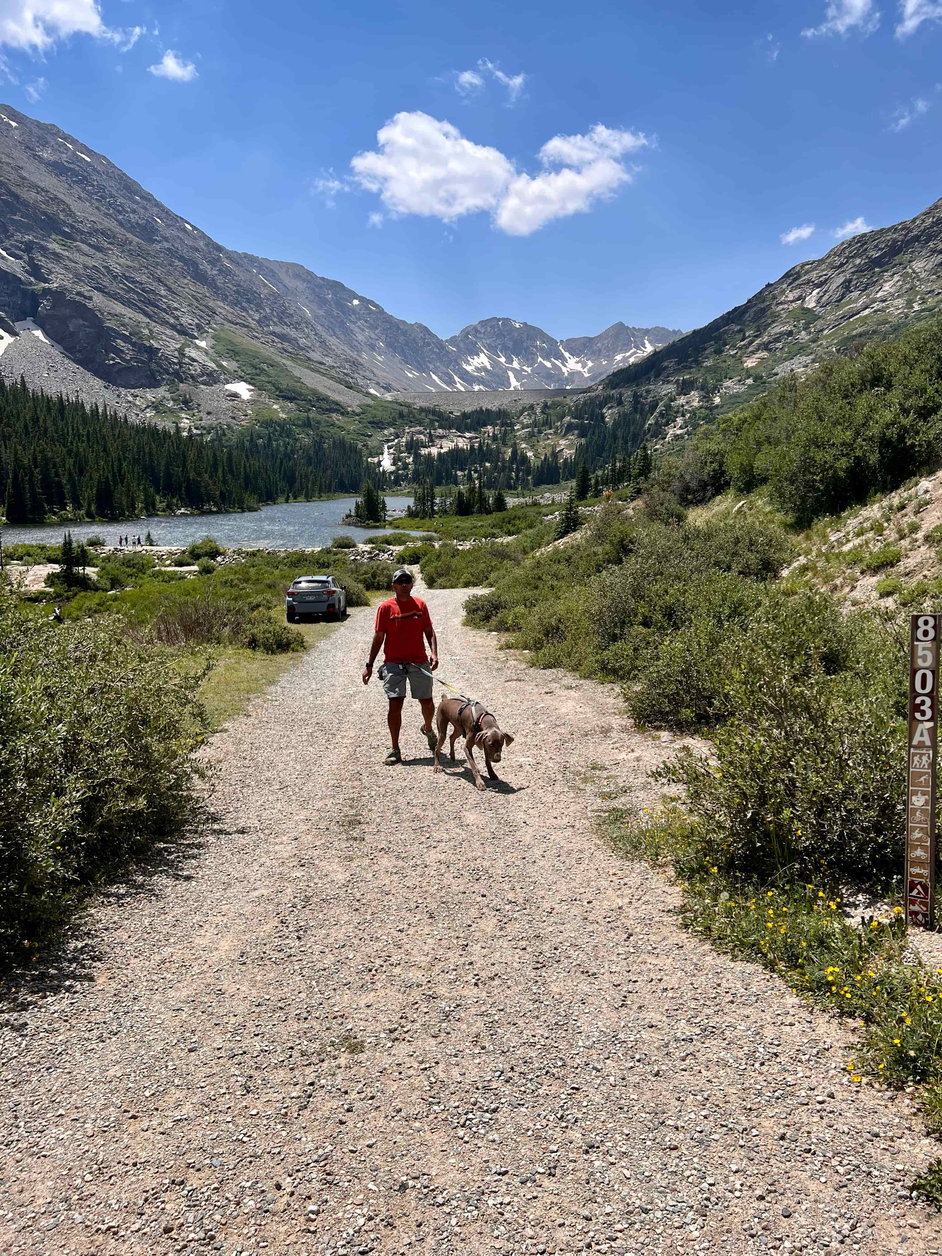 Man and dog walking up the trail near the Blue Lakes