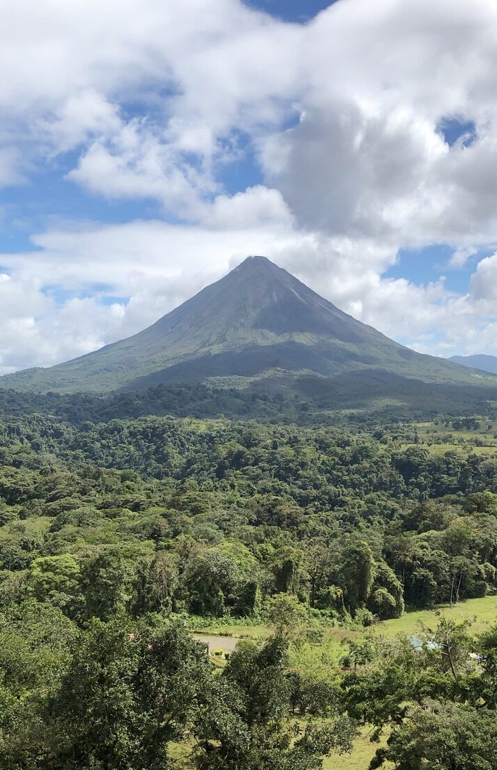 The cone of Arenal Volcano clear of cloud above the rainforest