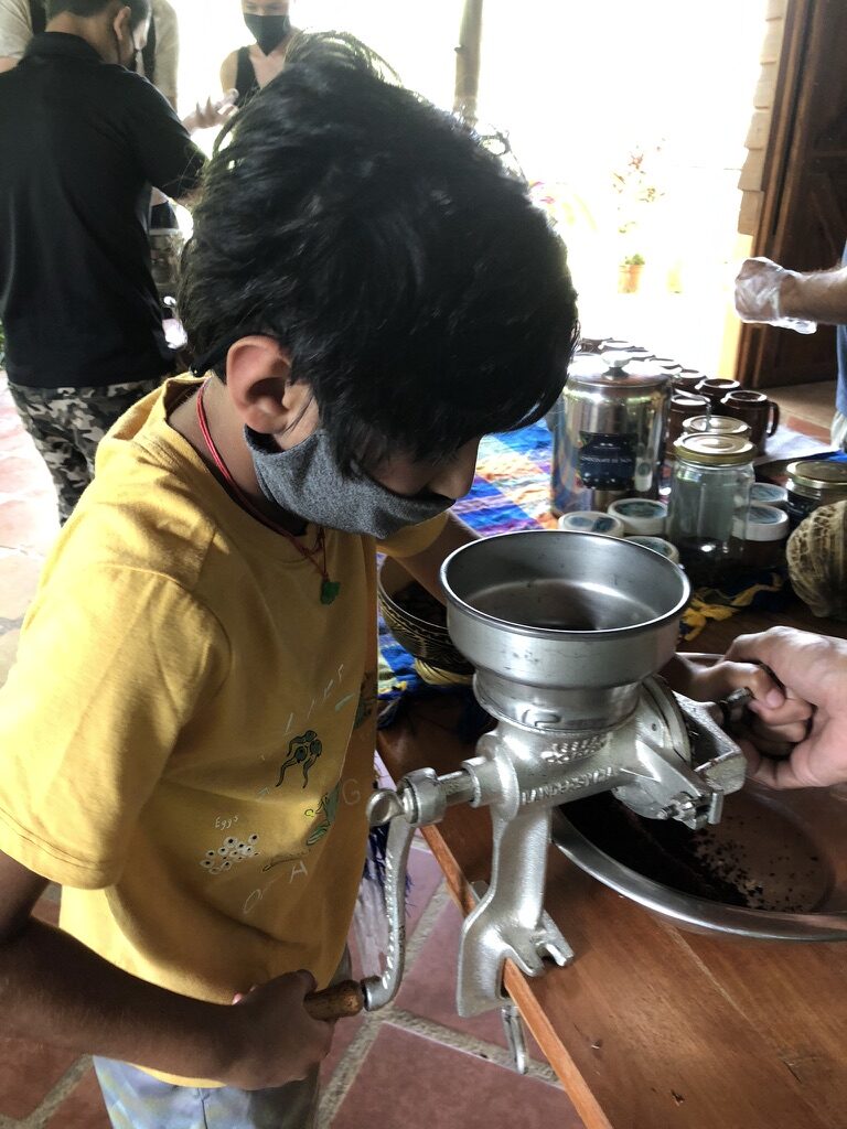 Boy turning the handle of a metal grinder