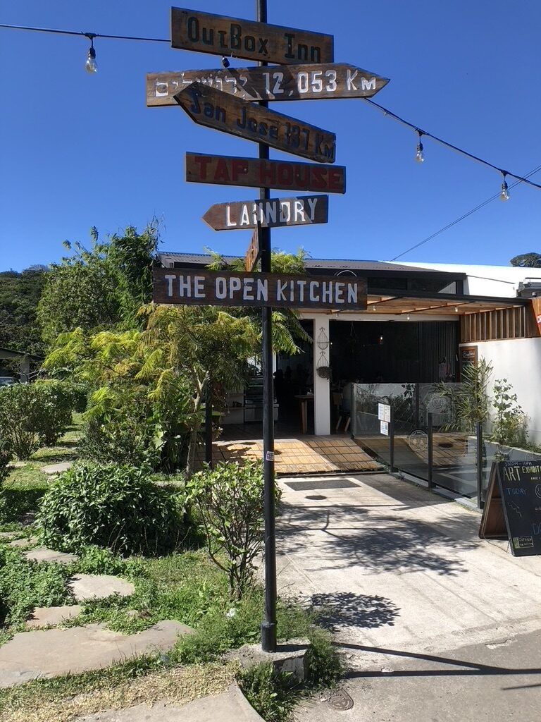 Wooden signposts in front of The Open Kitchen restaurant