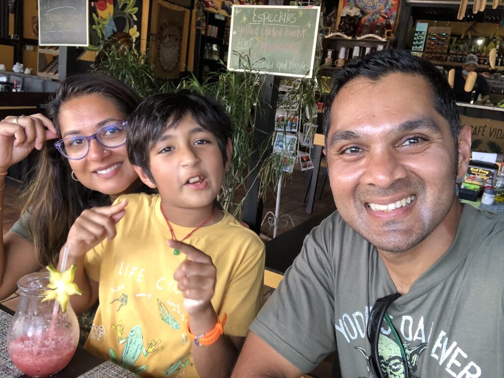 Woman, boy and man smiling at a table in the cafe