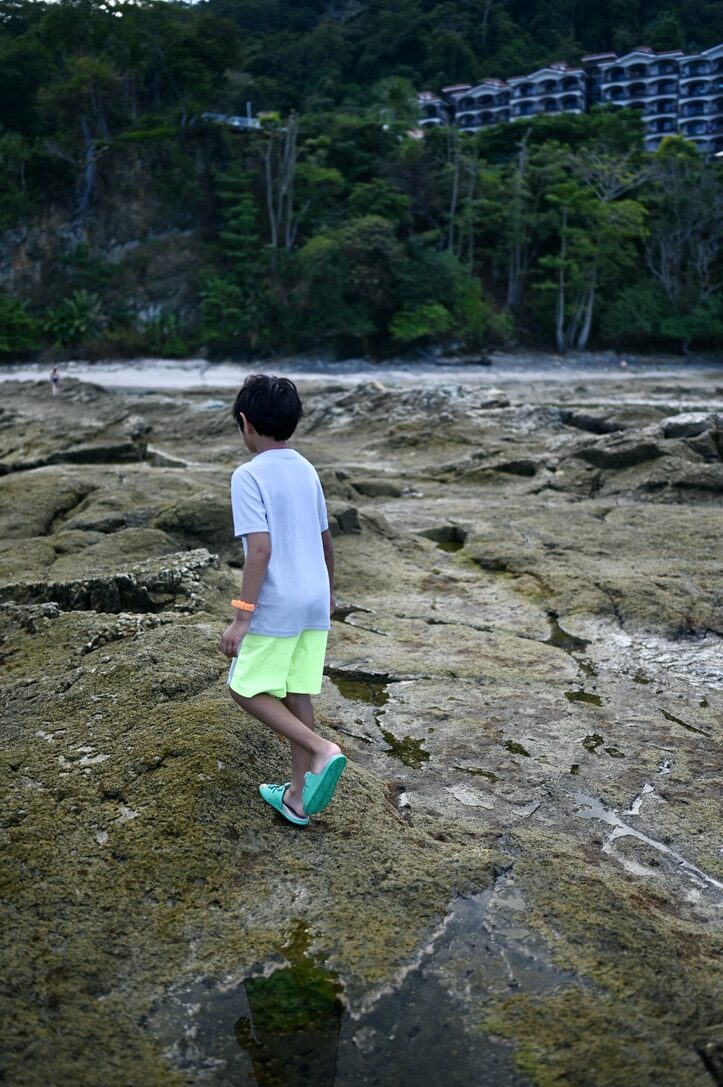 Boy exploring the rocky tide pools below the condos