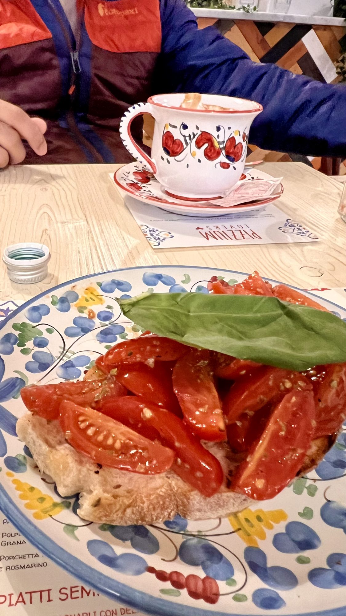 Bruschetta topped with fresh tomatoes and basil on a painted plate