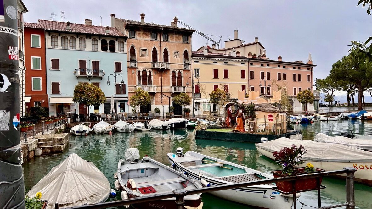 Small boats in front of pastel buildings at Desenzano del Garda’s harbor