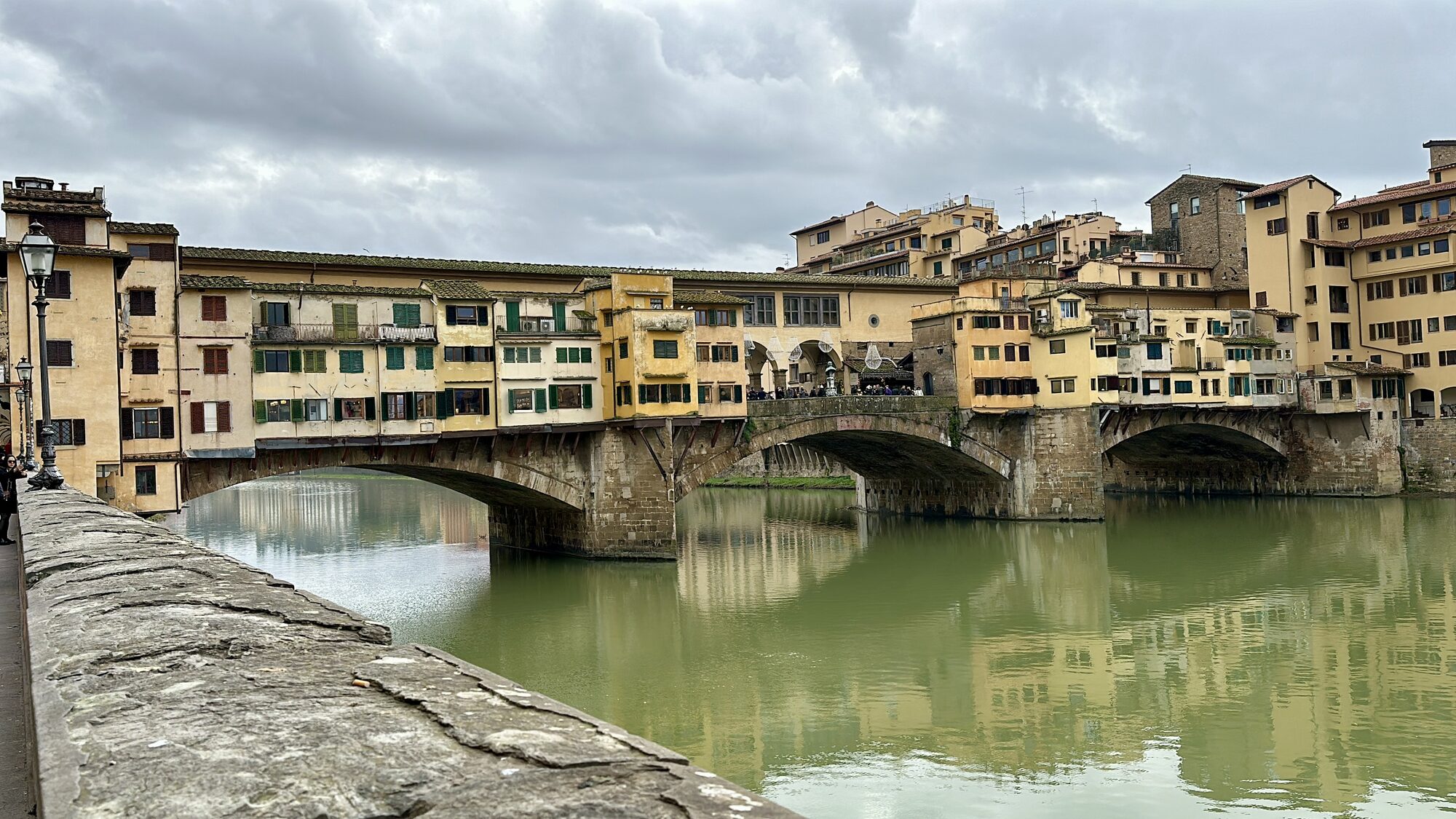 The Ponte Vecchio’s arches and shops reflected in the Arno