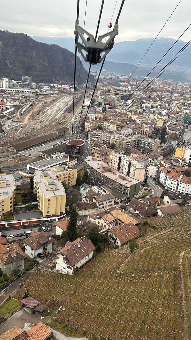 Looking down past the cable car’s wheels to the rooftops of Bolzano