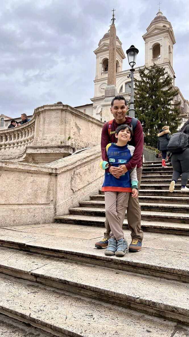 Man and boy on the Spanish Steps, with the church at the top behind them