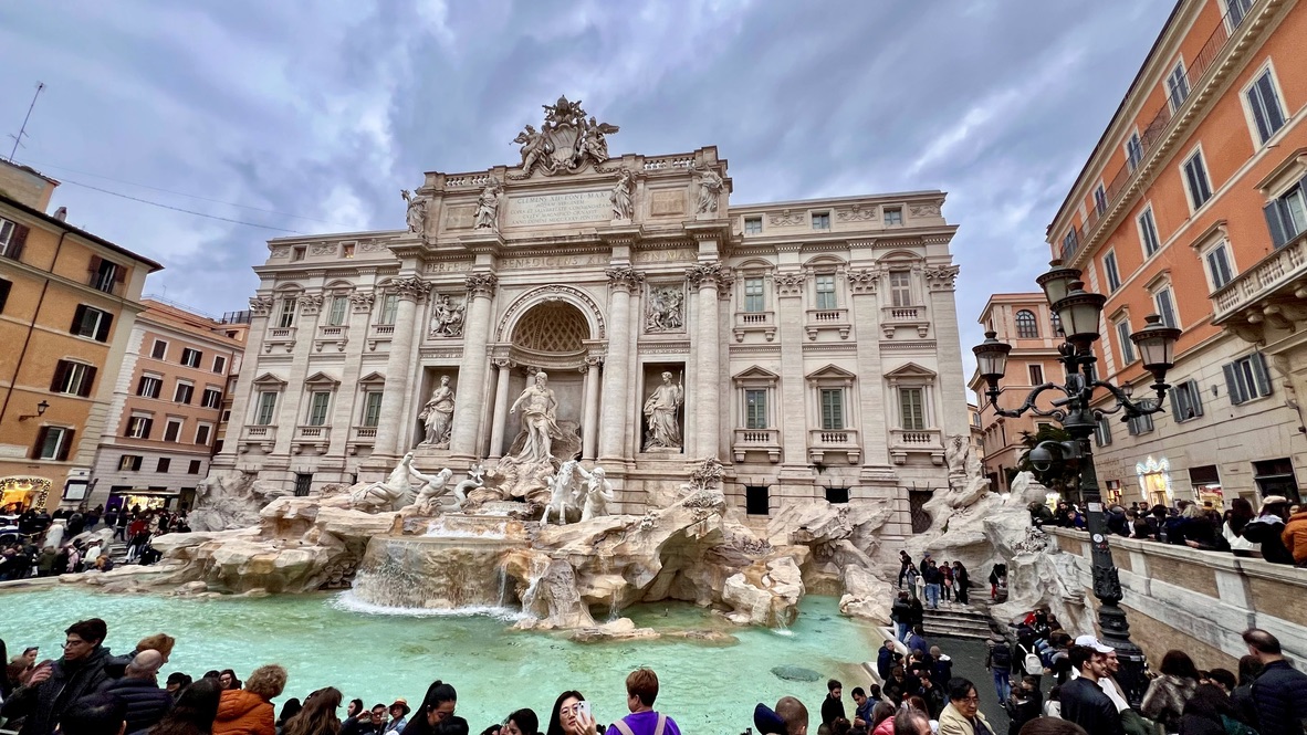 Huge fountain on the whole side of a building with mythical god statues all around