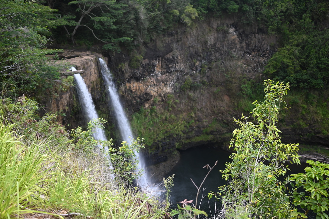 Two streams of waterfalls surrounded by lush tropical jungle, with sheer cliff walls