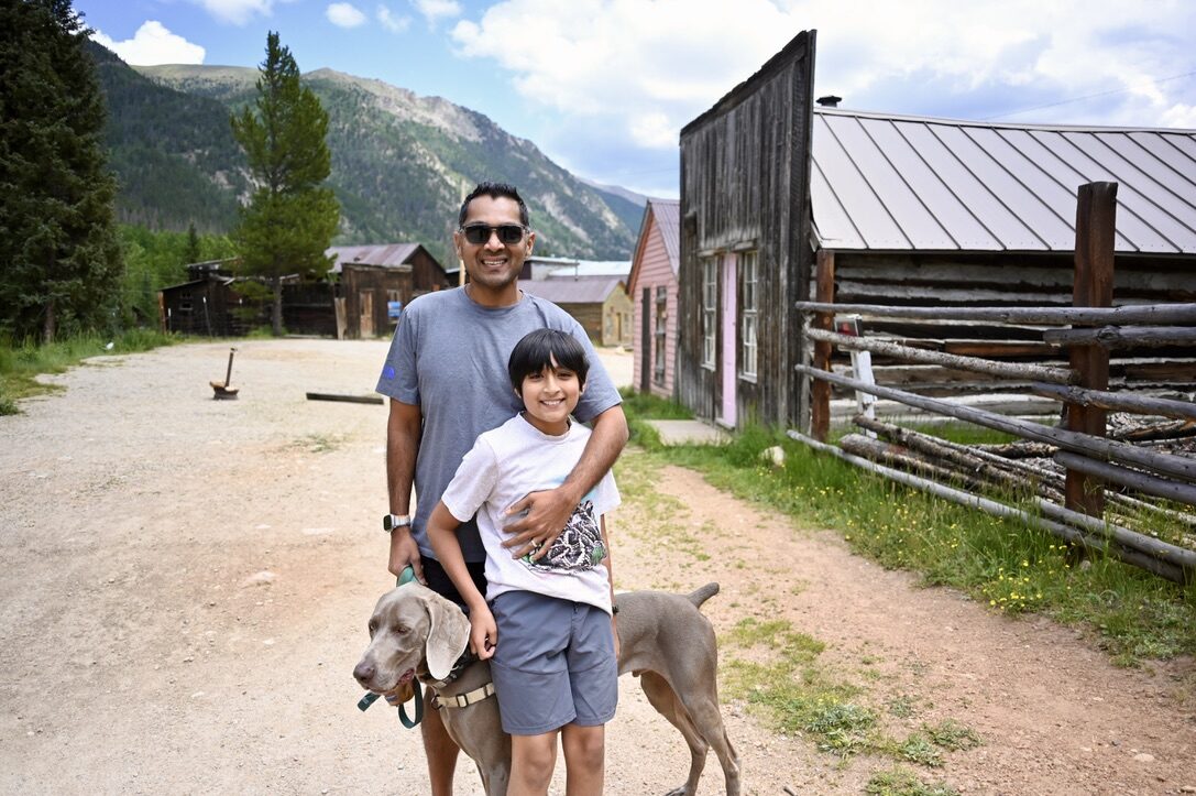 Man, boy and dog standing on the dirt street of the St. Elmo ghost town