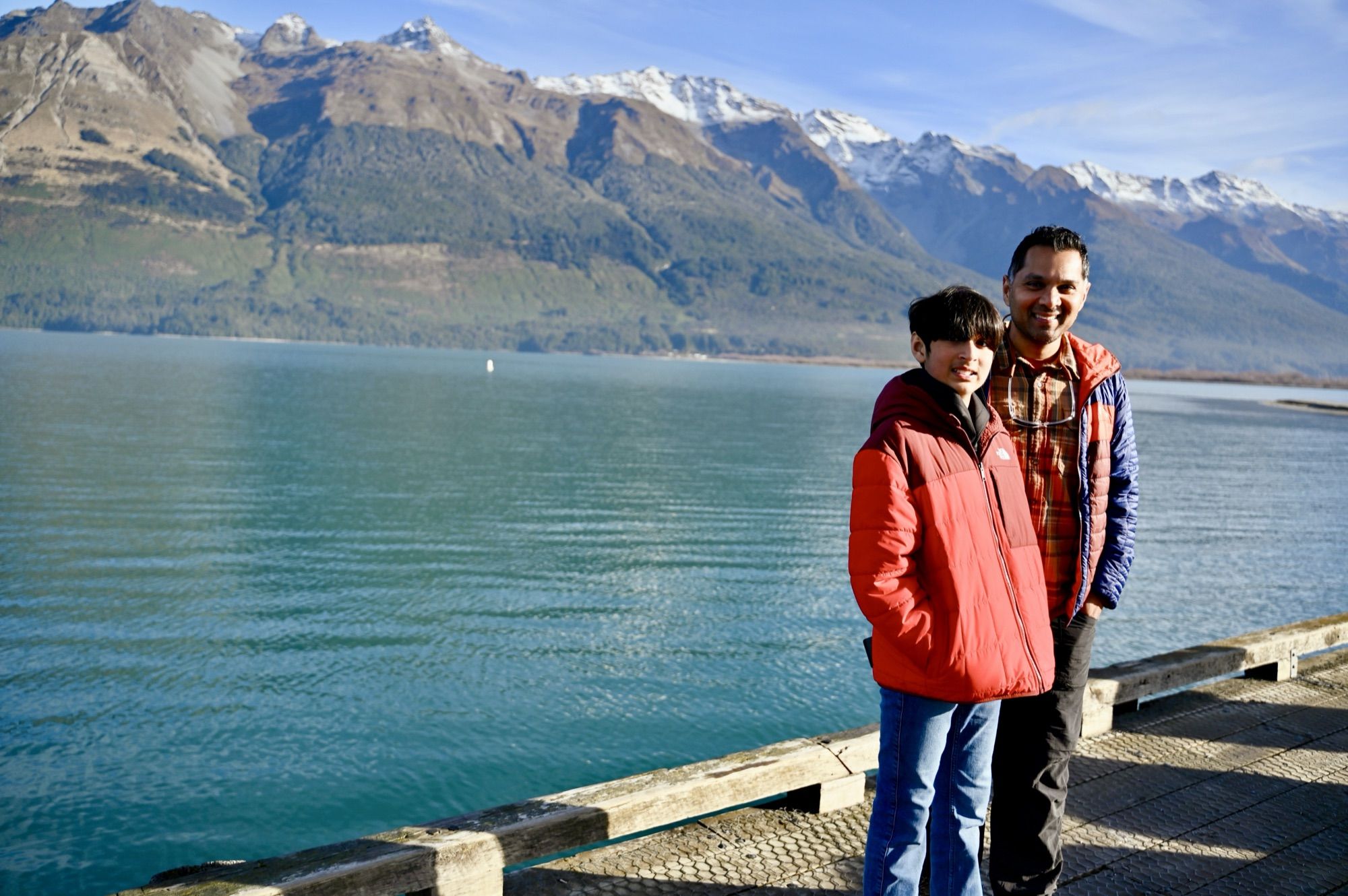 Our son and his dad on the Glenorchy wharf, with turquoise water and snow-capped mountains behind them.