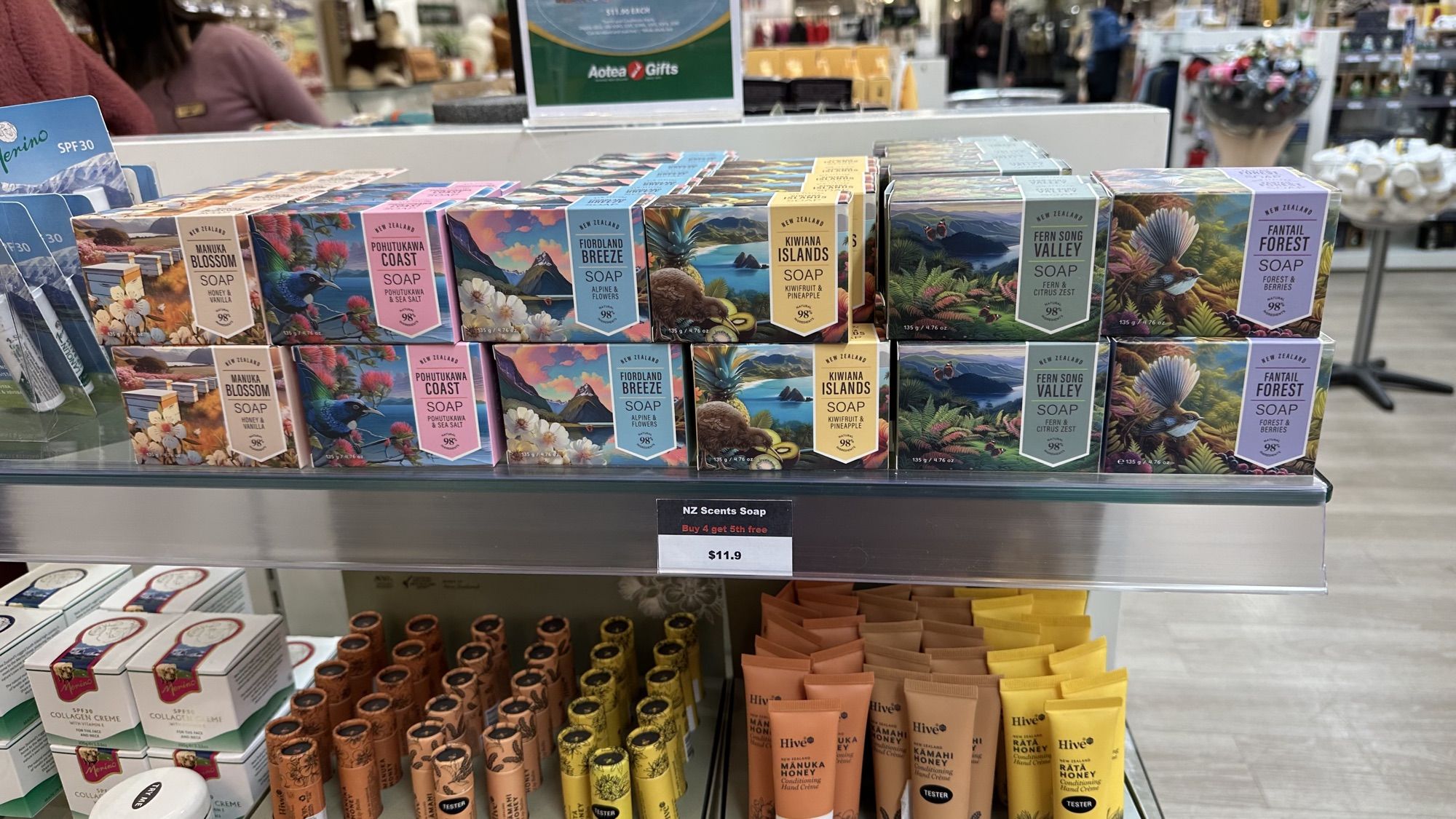 Shelves of colourful New Zealand soap boxes with illustrated landscapes in a gift shop.