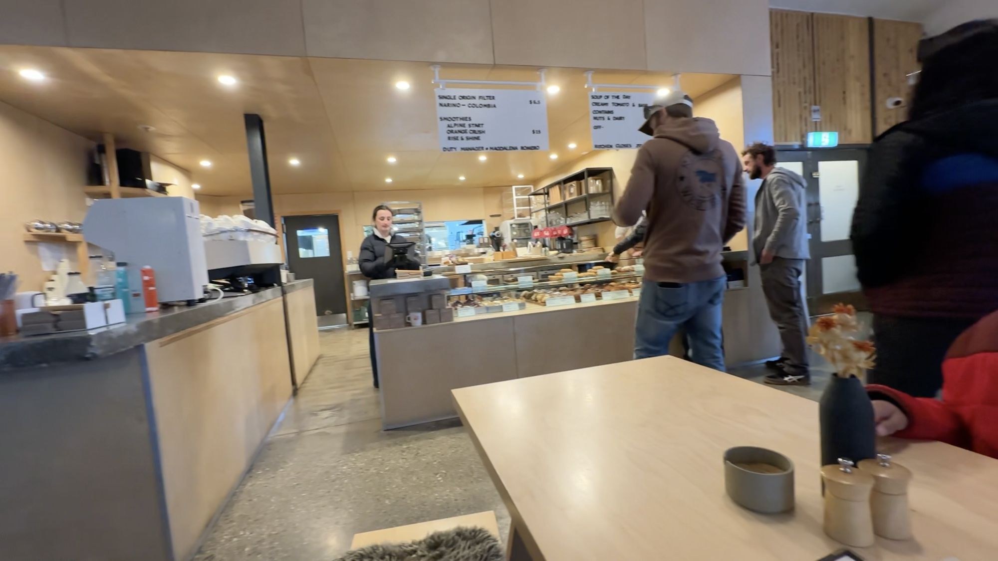 The counter at Scroggin, with a pastry cabinet, an espresso machine and handwritten menu boards above.