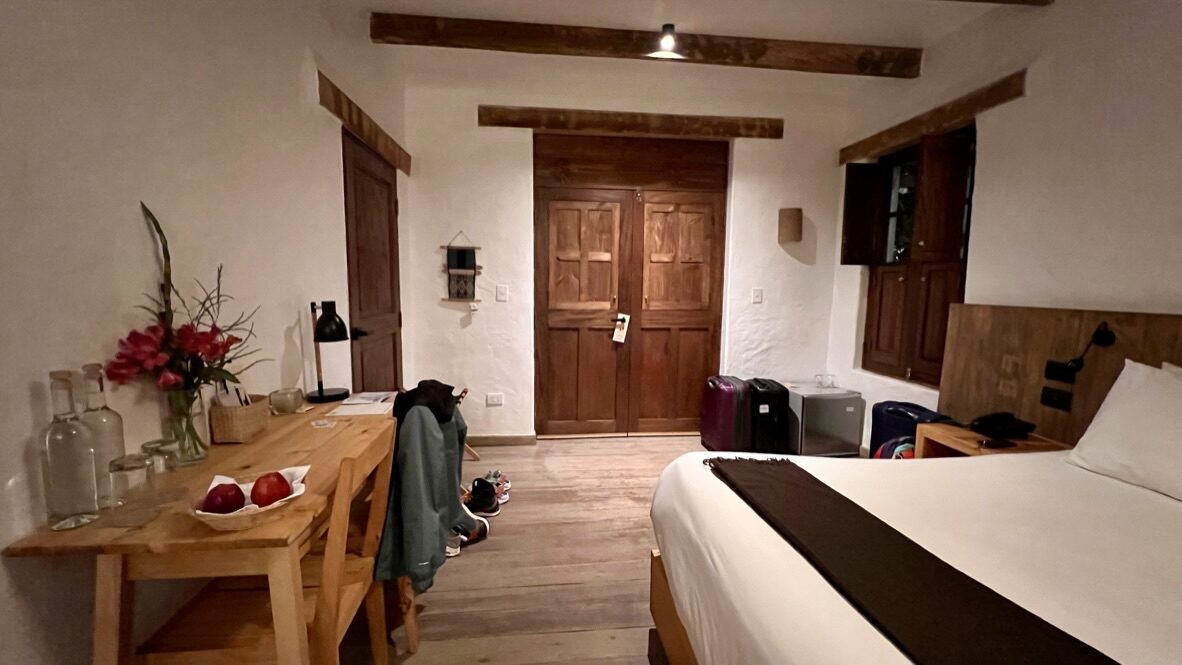 A cozy hotel room with wooden doors, a desk and flowers