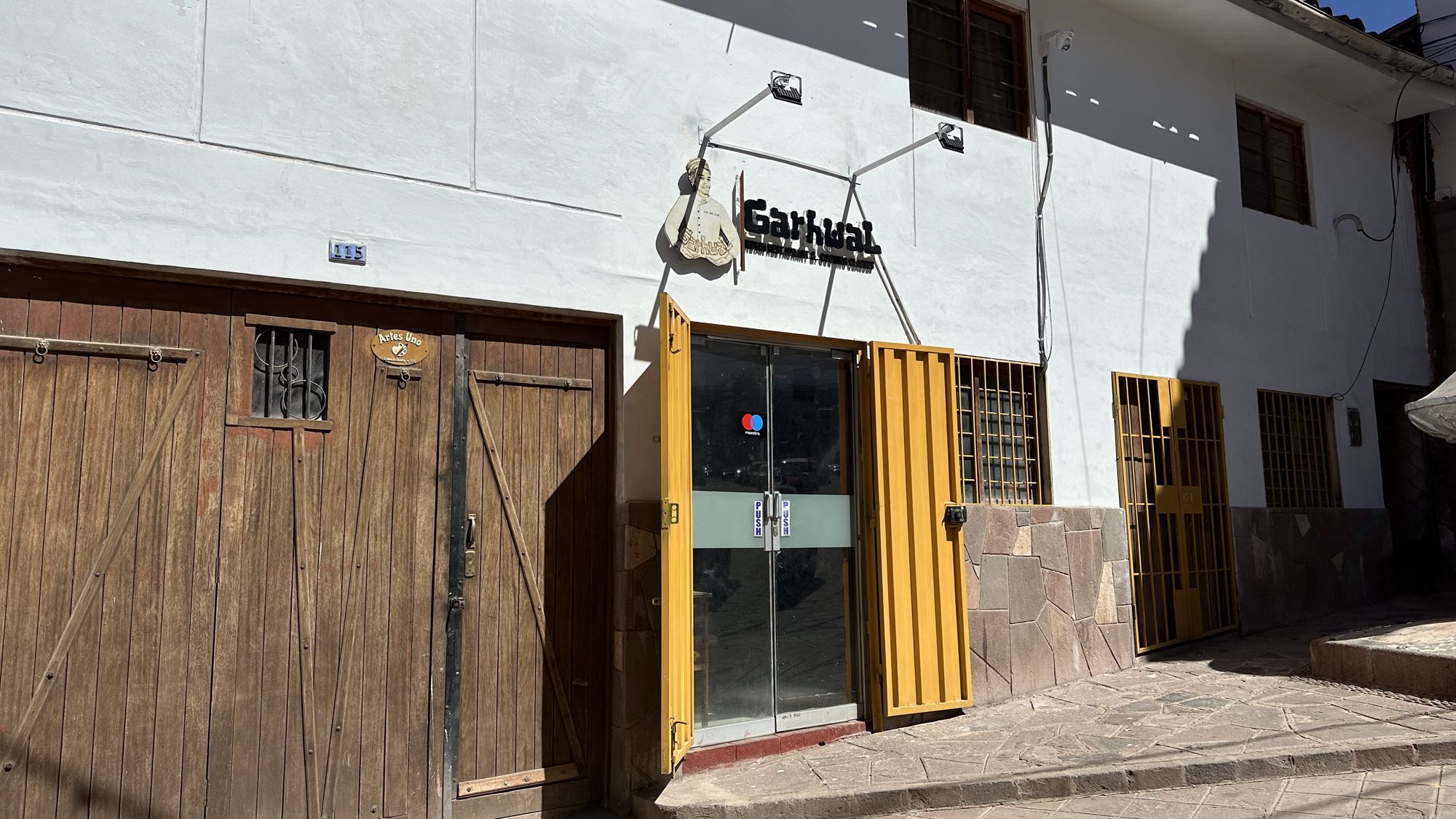 The plain storefront of Gharwal restaurant beside wooden doors