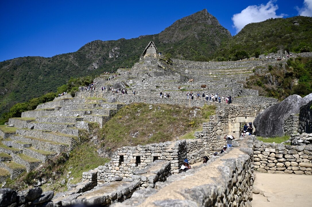 Stone ruins and grassy terraces climbing toward the mountains