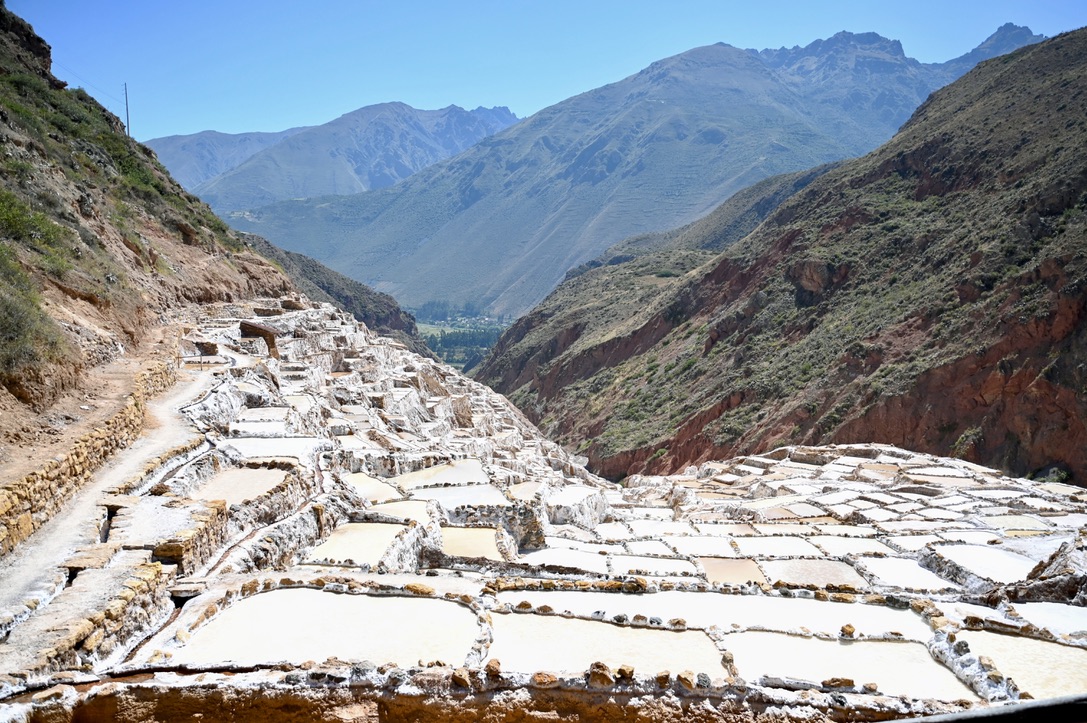 Mountains and vallys, with one side of a mountain covered by salt mine flats.