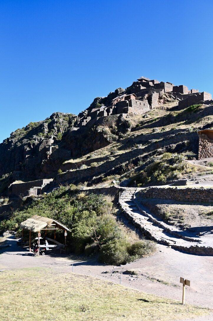 Stone ruins on a rocky hilltop above a trail