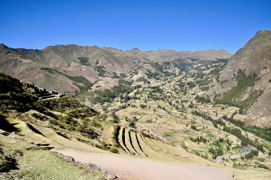 A wide green valley with terraced fields, seen from the Pisac ruins