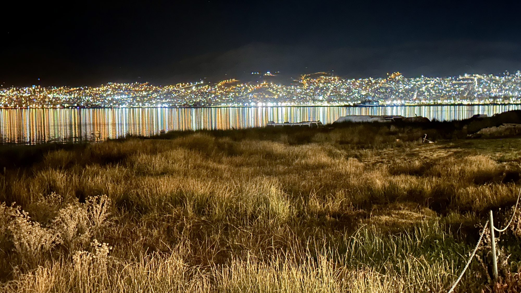 The lights of Puno reflected across Lake Titicaca at night
