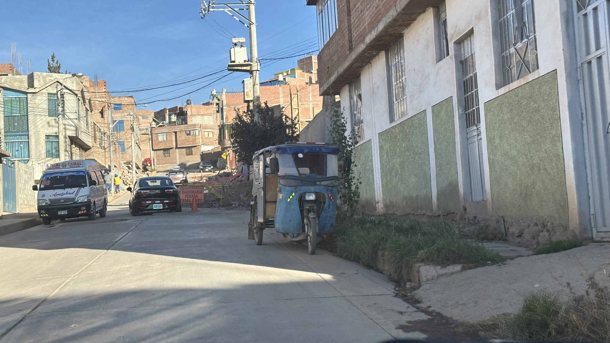 A street in Puno with a parked tuk-tuk and houses
