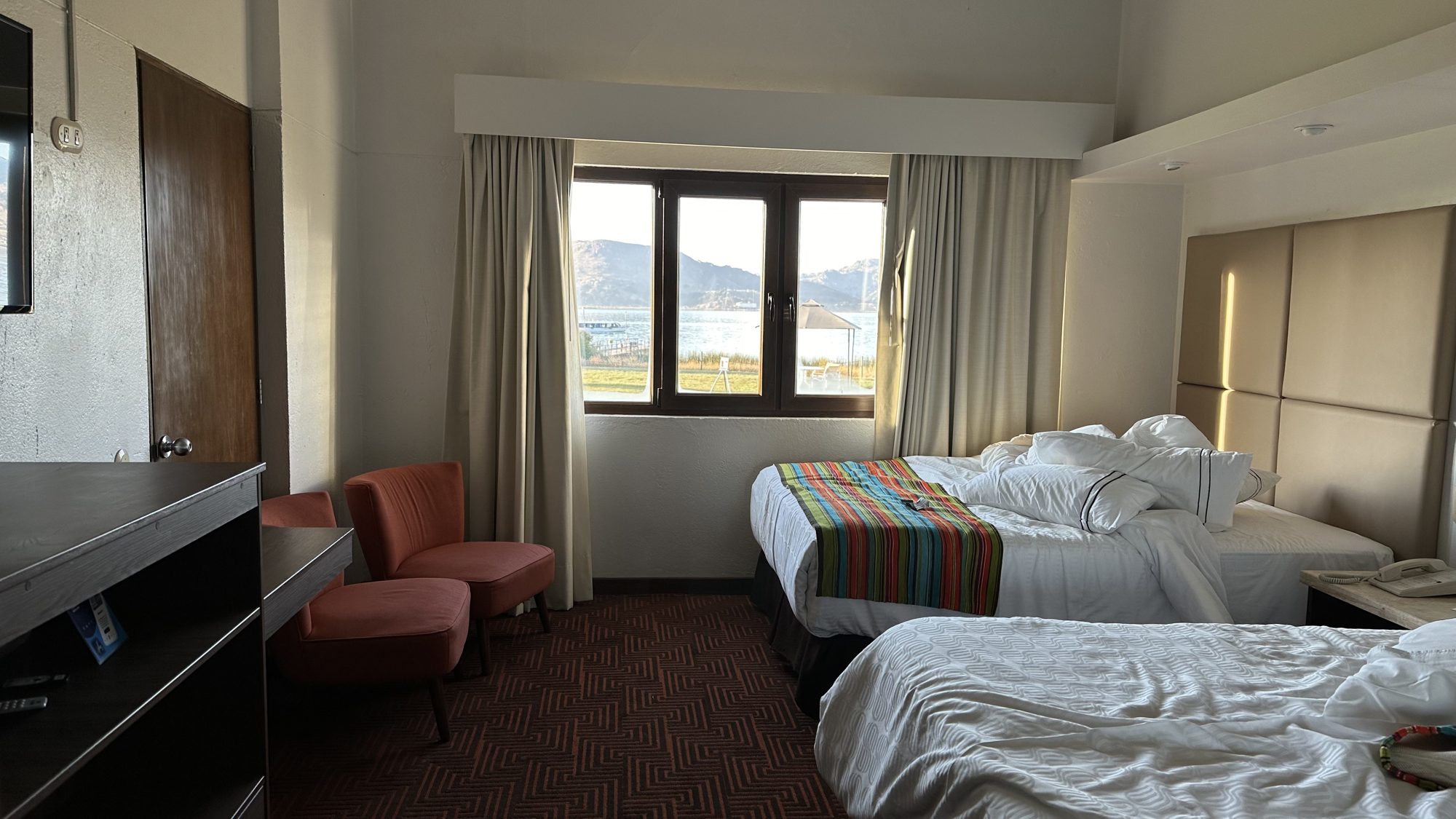 A hotel room with twin beds and a window onto the lake