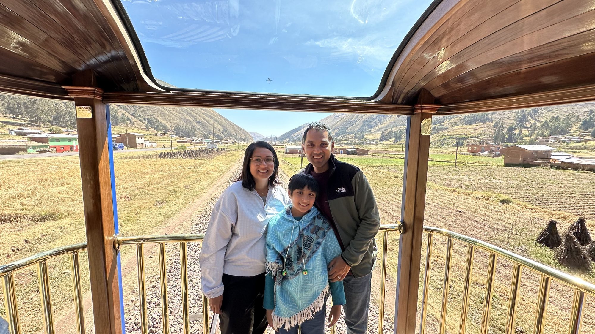 Woman, boy and man smiling in the open observation car