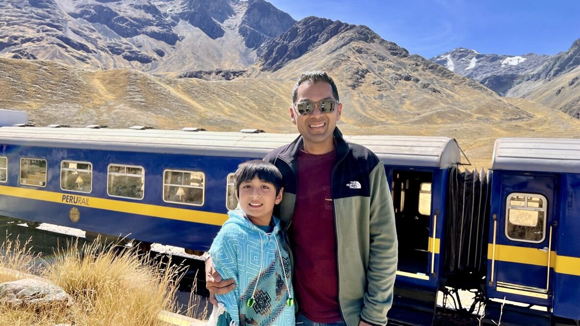 Man and boy smiling beside the train at the village stop