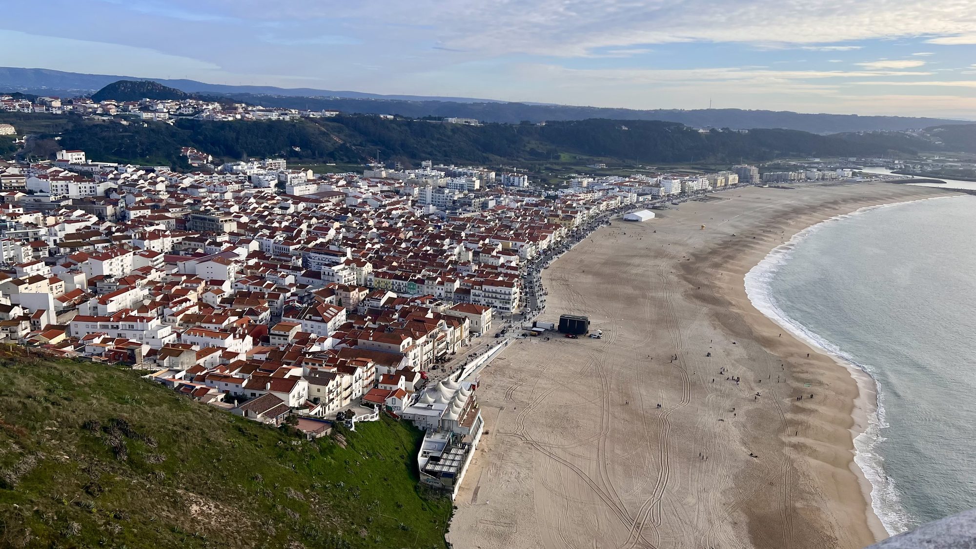 Nazaré’s white houses and long curving beach seen from high up on the hill.